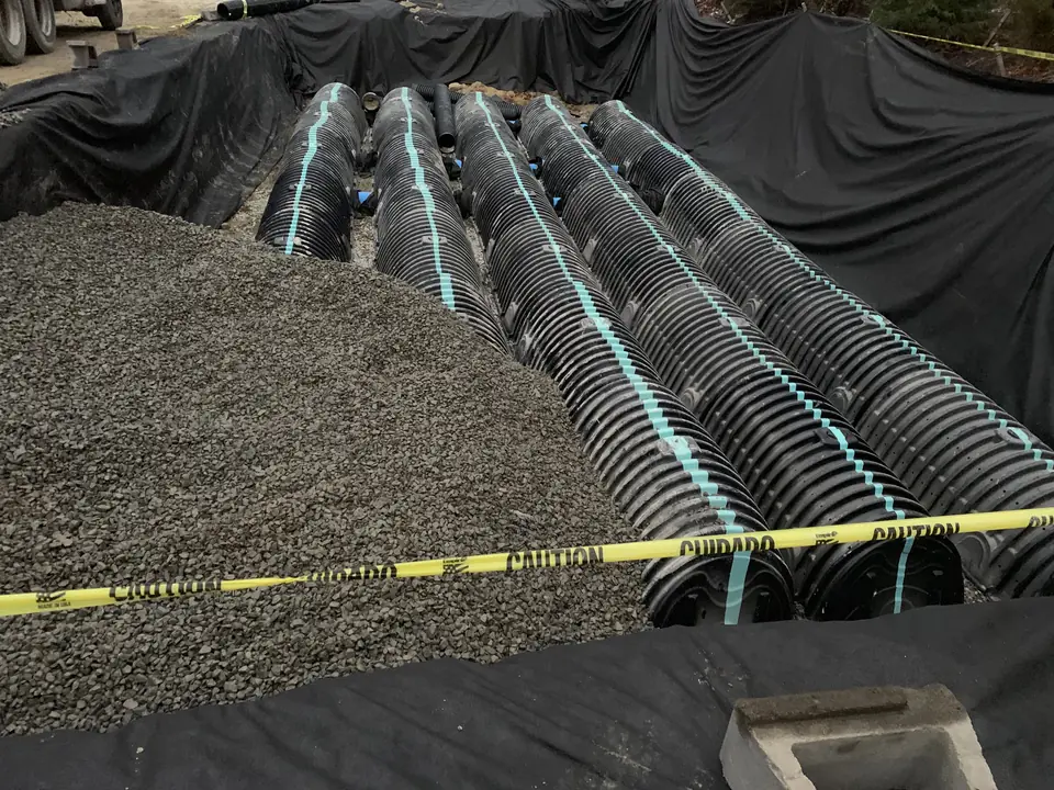 Stormwater infiltration chambers set in crushed stone