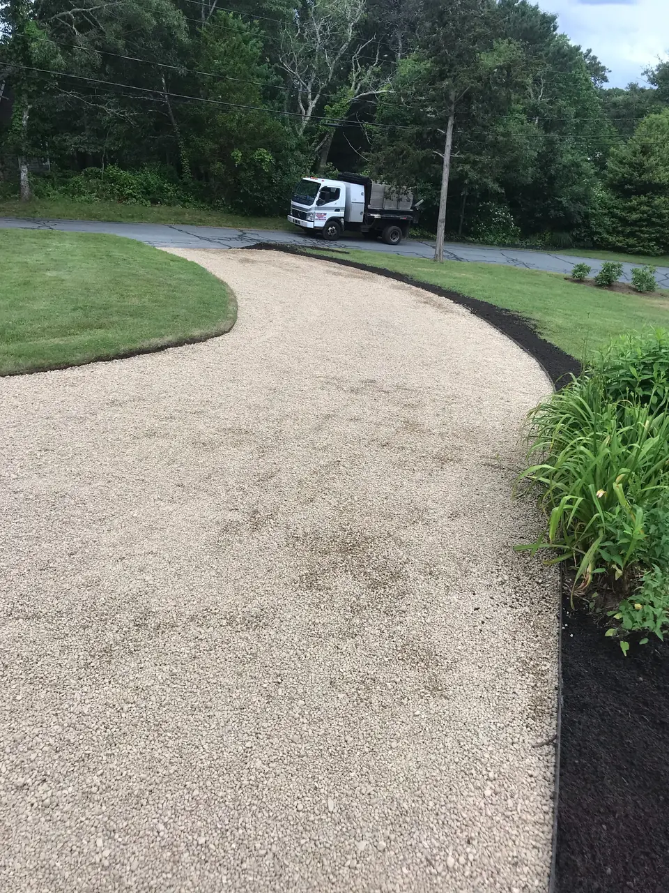 Crushed stone driveway along a new lawn