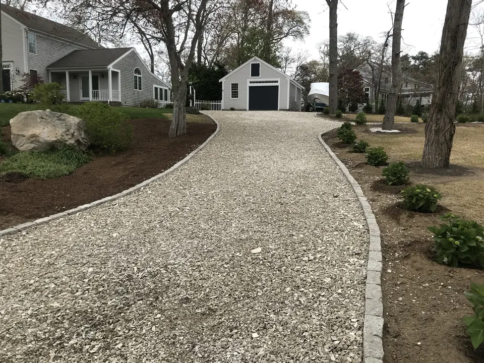 Long crushed stone driveway edged in cobblestone