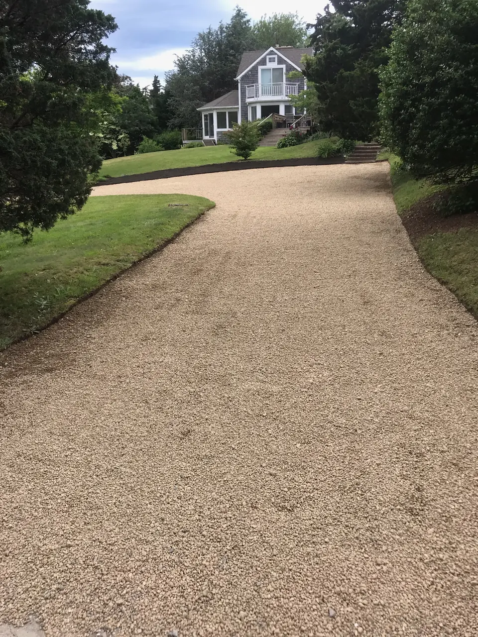 Crushed stone driveway between two lawns