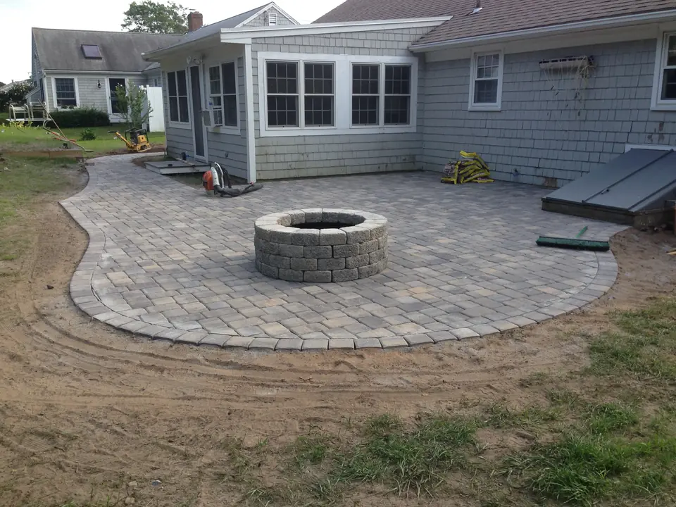 Curved paver patio and fire pit off the back of the house