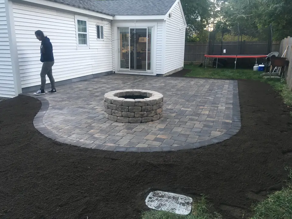 New paver patio and fire pit, with the loam ready for the lawn