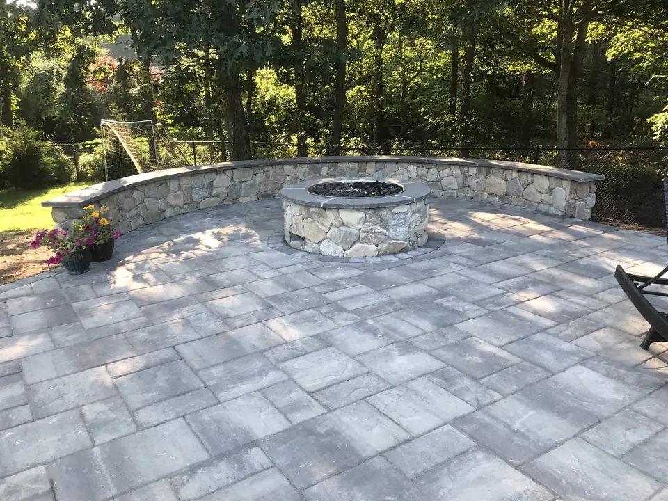 Fieldstone seat wall and fire pit with bluestone caps, on a paver patio