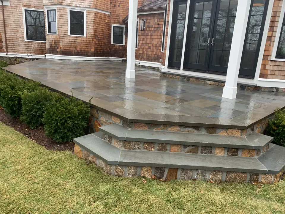 Raised bluestone patio with fieldstone veneer and wrap-around steps