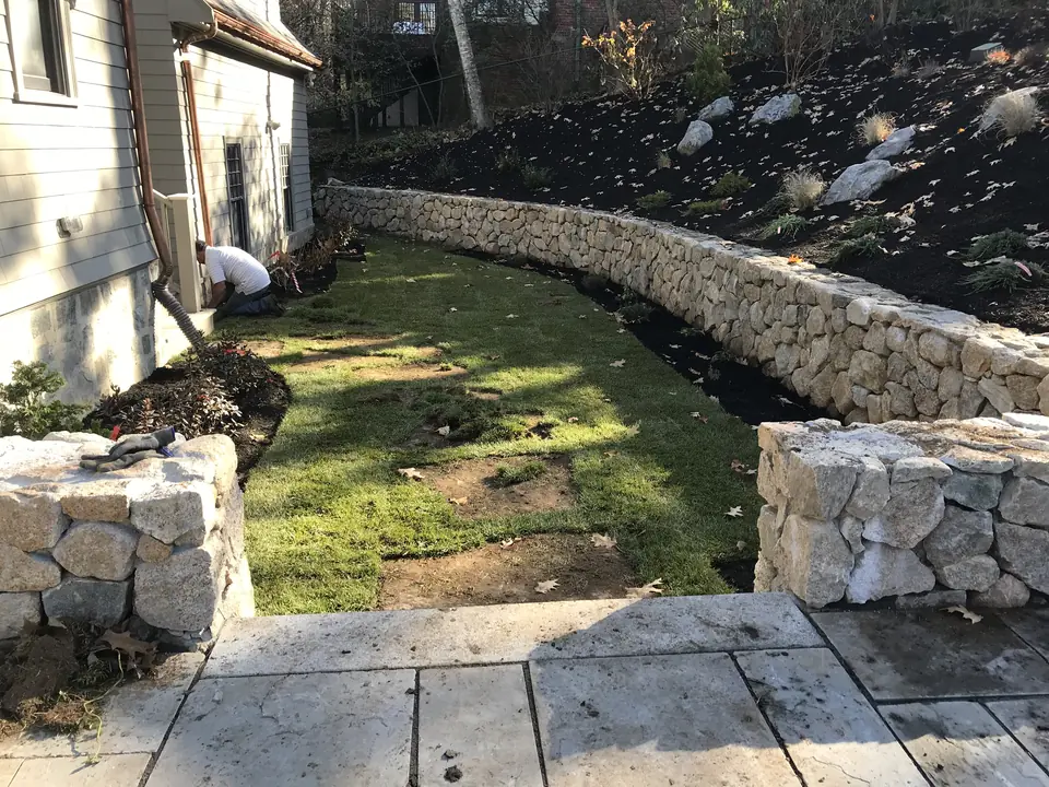 Fieldstone retaining wall above a new lawn