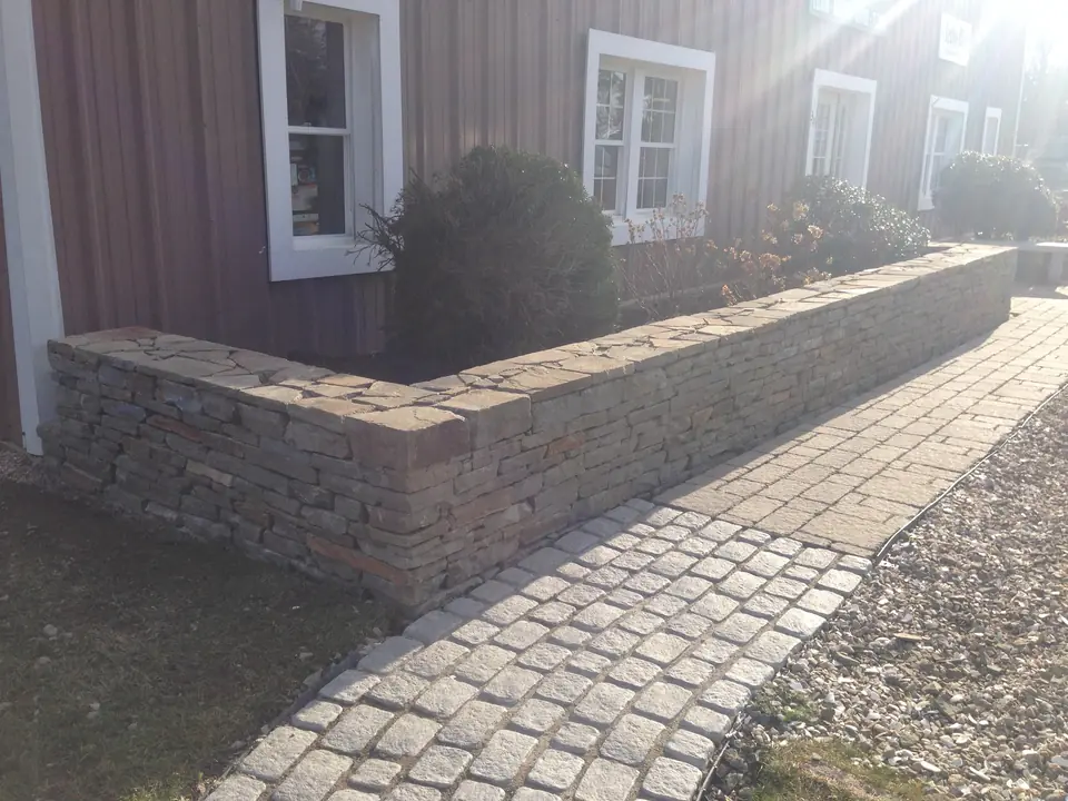 Block garden wall beside a cobblestone walk