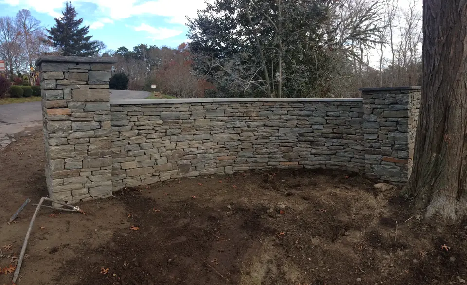 Curved stone wall between two pillars