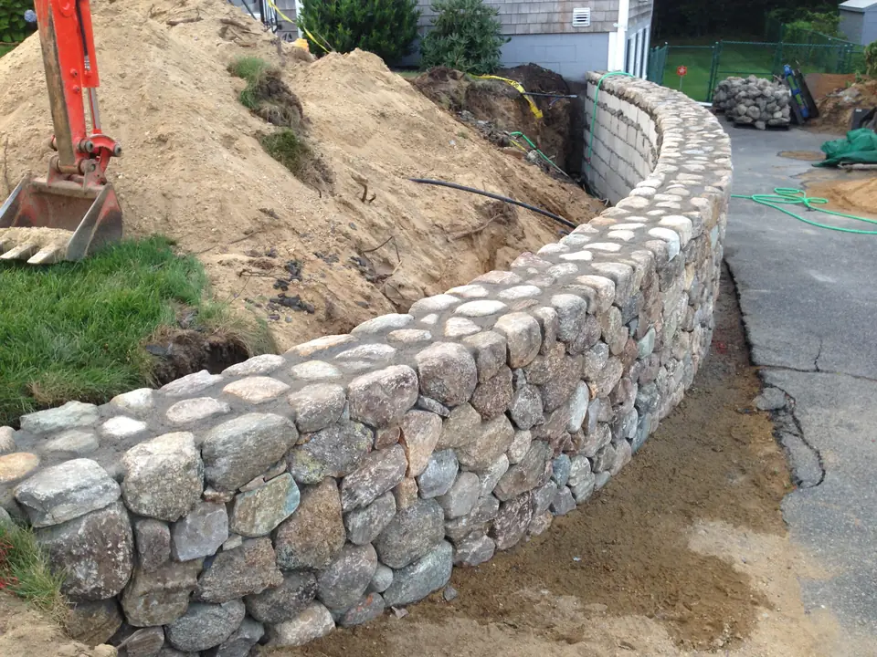 A fieldstone wall holding a cut slope