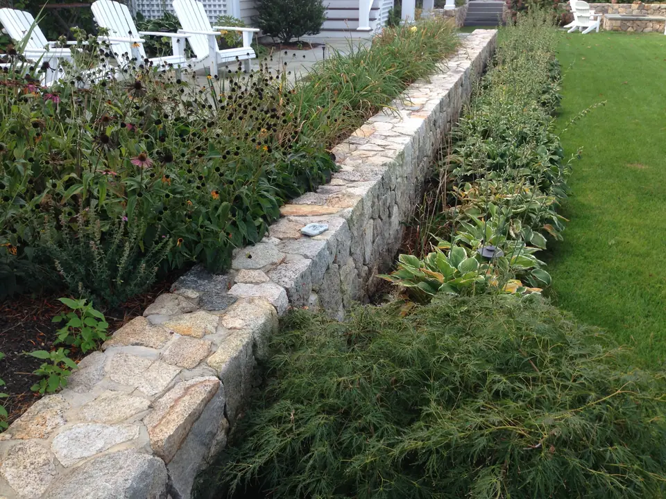 Low fieldstone garden wall along a lawn