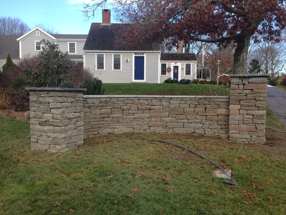 Stone wall and pillars in front of a Cape