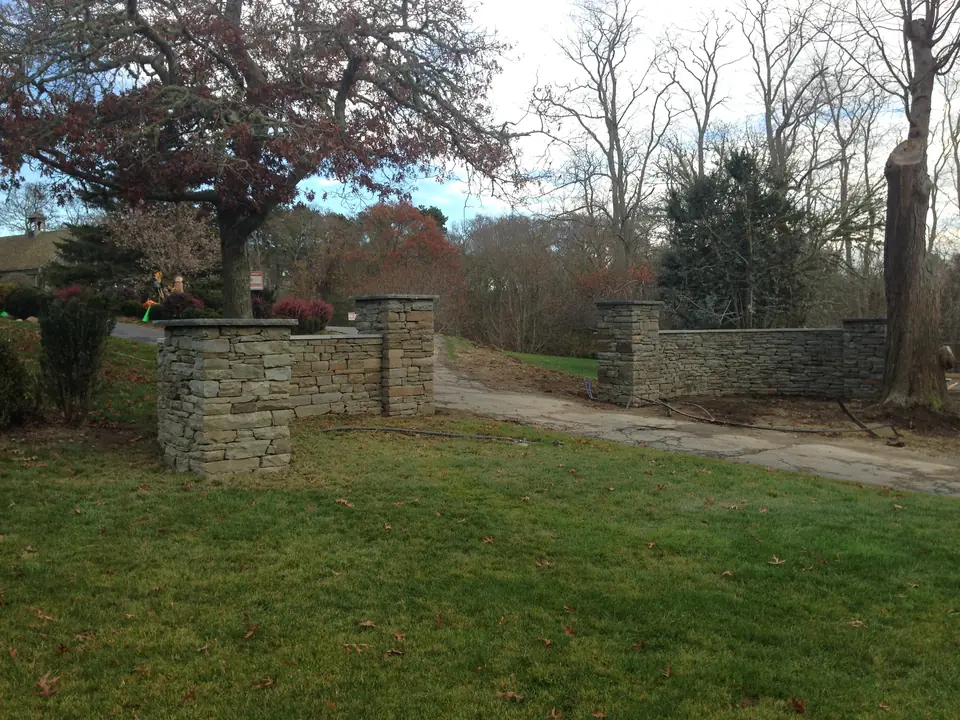 Stone wall with pillars at the front of the property