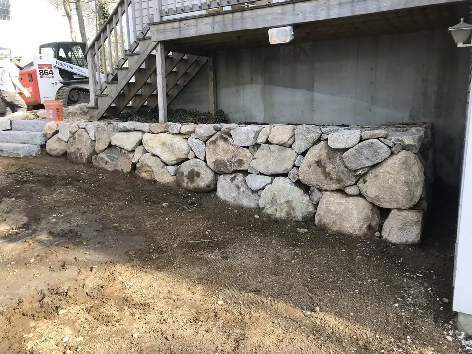 Boulder wall under a deck, during construction