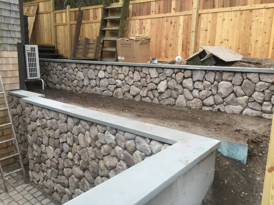 Fieldstone veneer going onto a retaining wall